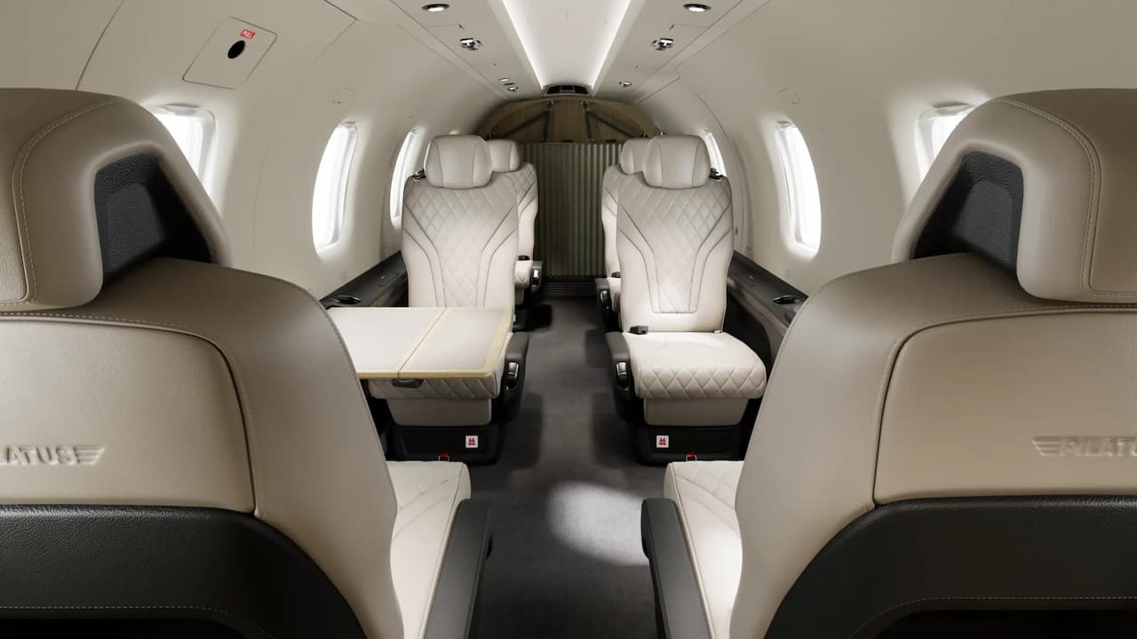 Interior of a Pilatus PC-12 with light-colored leather seats and a center table
