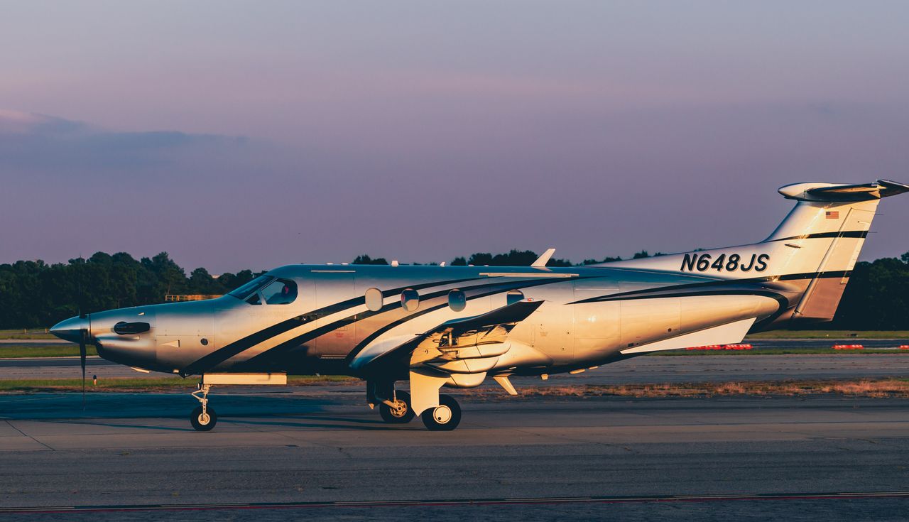 A Pilatus PC-12 PRO taxiing at sunset, seen in profile